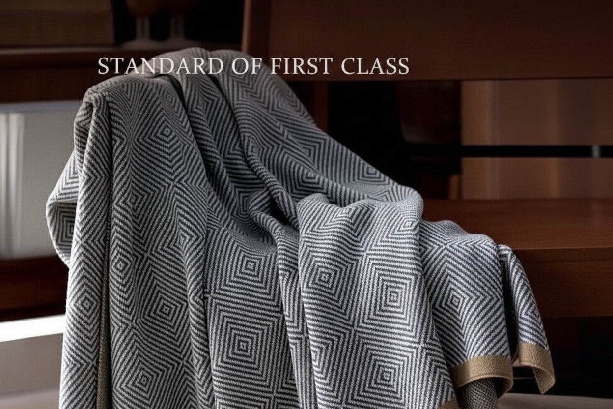Patterned blanket draped over a chair with text indicating 'Standard of First Class' and 'First class headrest cover series'.