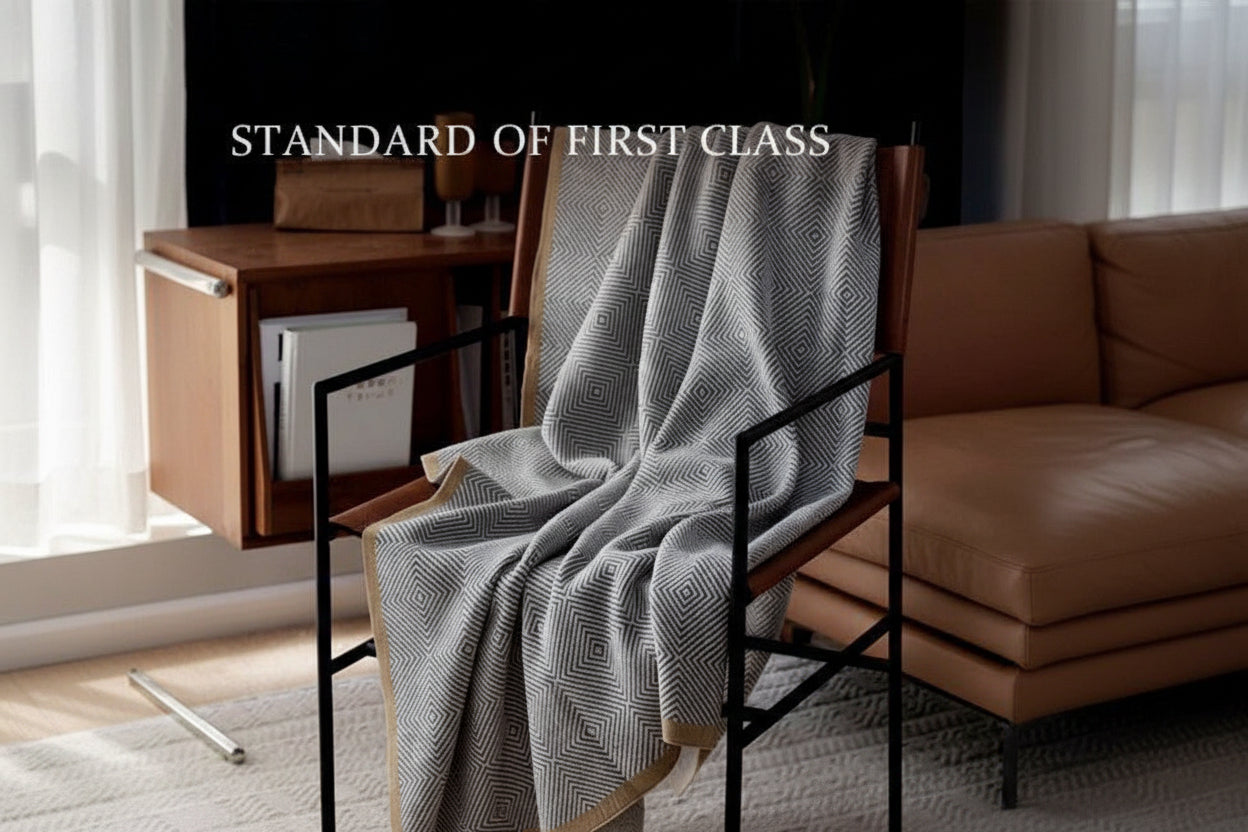 Gray patterned blanket draped over a chair with text 'Standard of First Class' and Chinese characters.