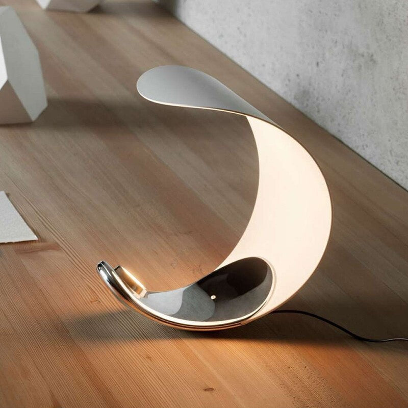 Modern floor lamp with a curved design on a wooden floor.