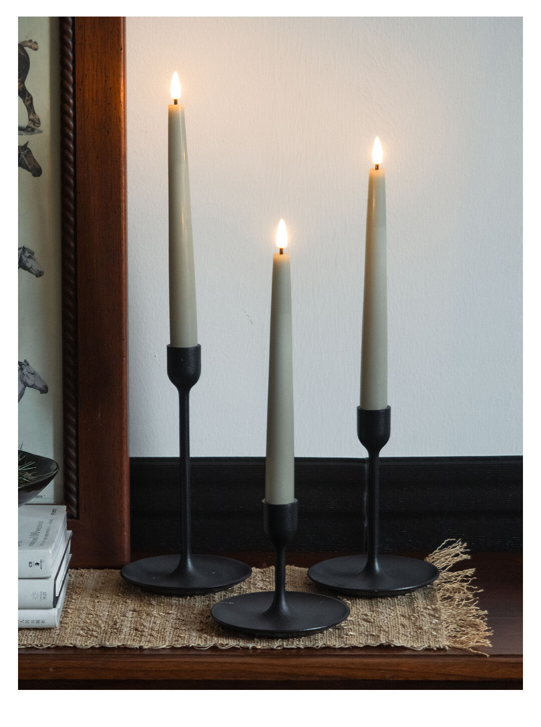 Three candle holders with candles on a wooden surface